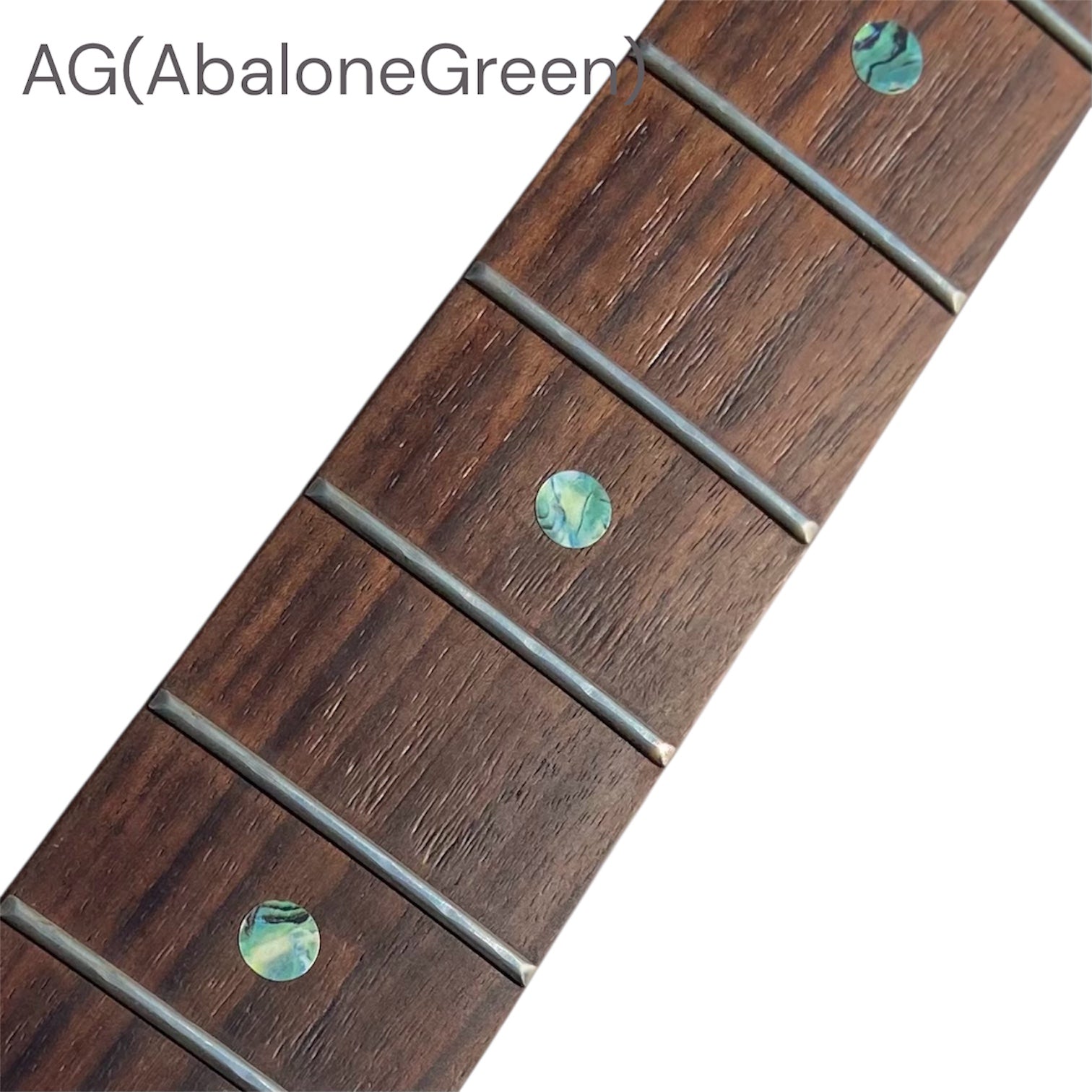 Close-up of a guitar fretboard with abalone green dot inlay stickers